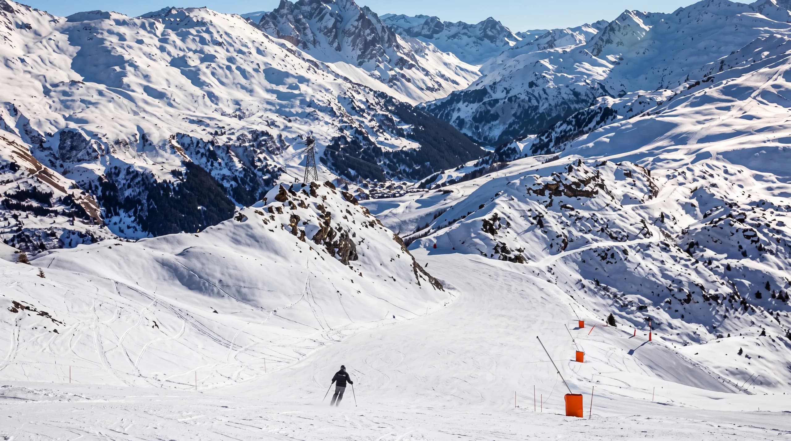 Skieurs sur la piste mythique du Roc de Fer à Méribel, avec vue panoramique sur les 3 Vallées