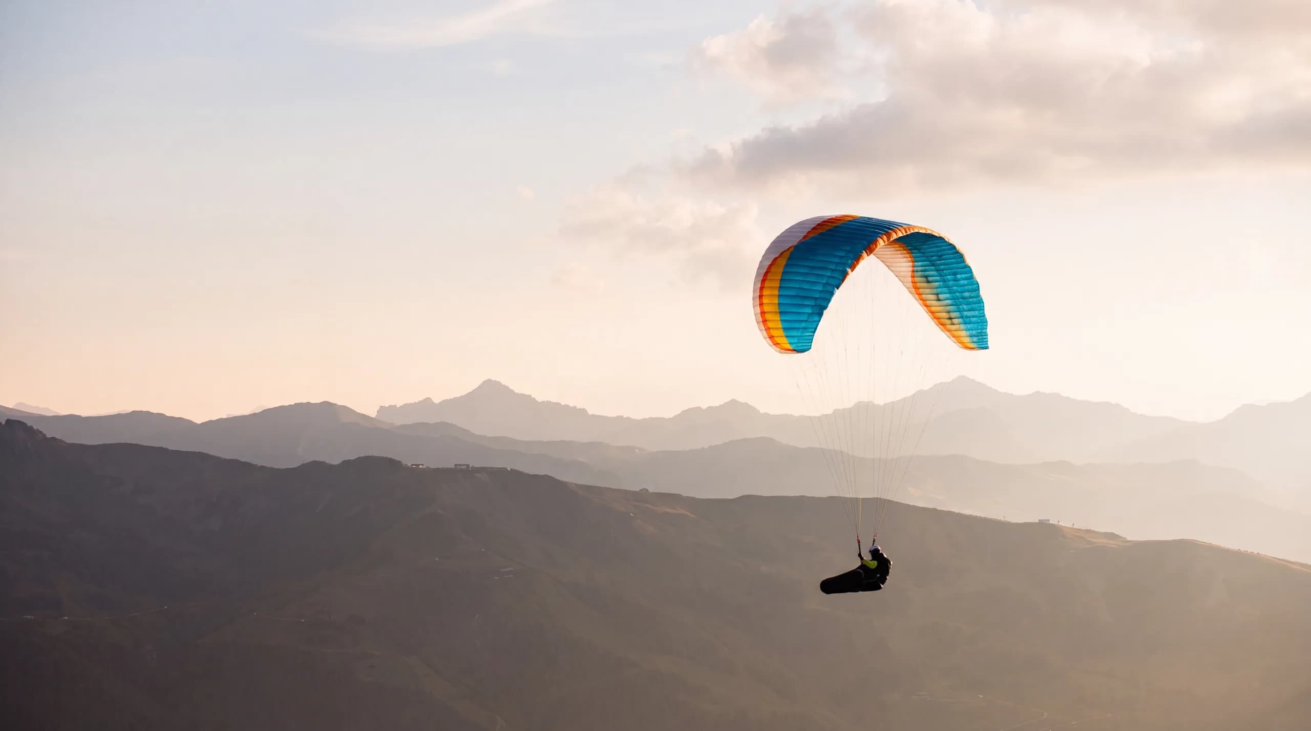 Parapente biplace en vol au-dessus du domaine enneigé des 3 Vallées depuis l'Altiport de Méribel