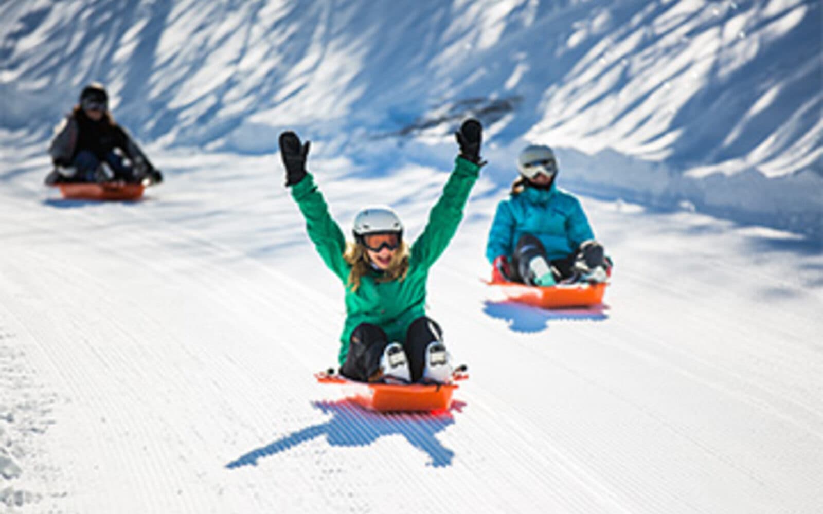 Enfants en luge sur la piste Mission Black Forest dans la forêt enneigée de Méribel-Mottaret
