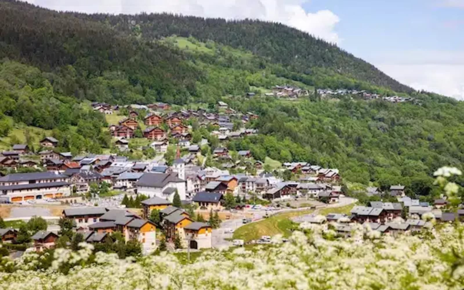 Vue du village savoyard des Allues avec son église Saint-Martin et ses chalets en bois